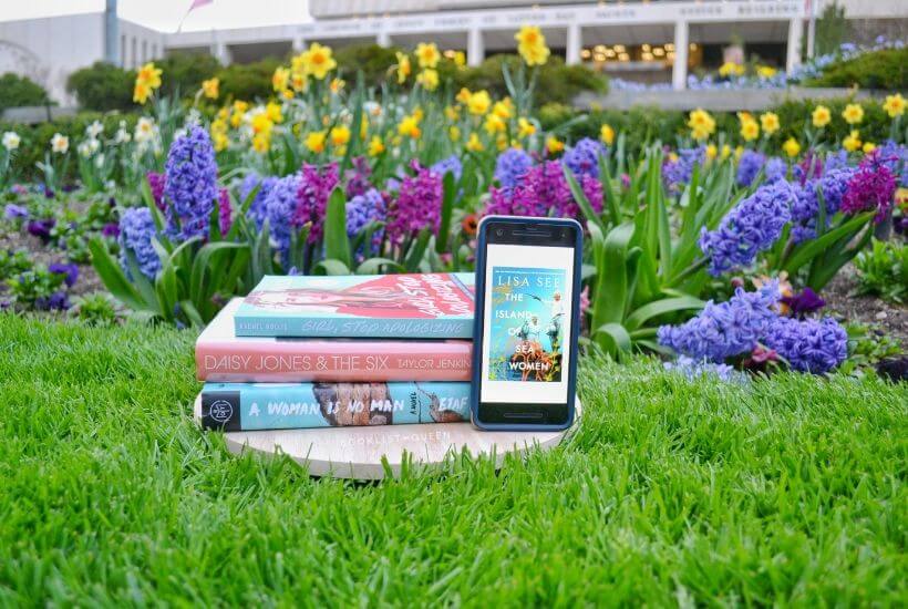 bookstack and e-book among spring flowers